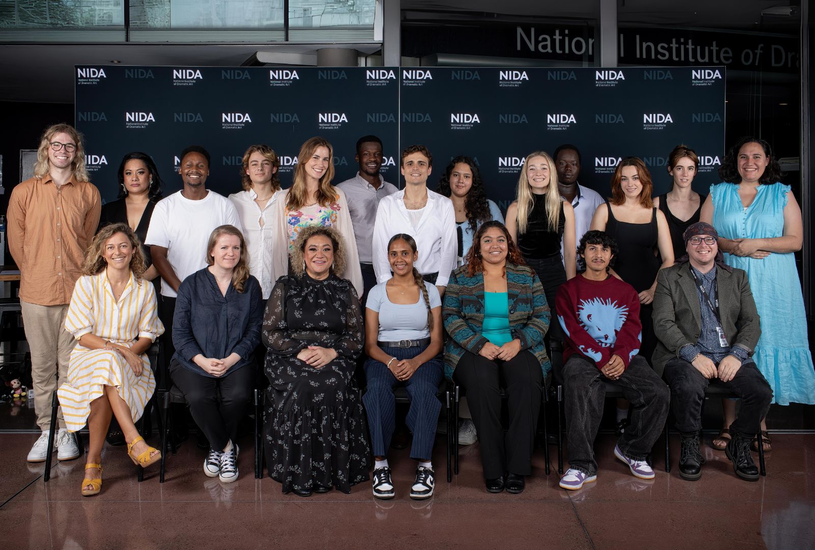 2024 Scholarship recipients standing in front of the NIDA wall.