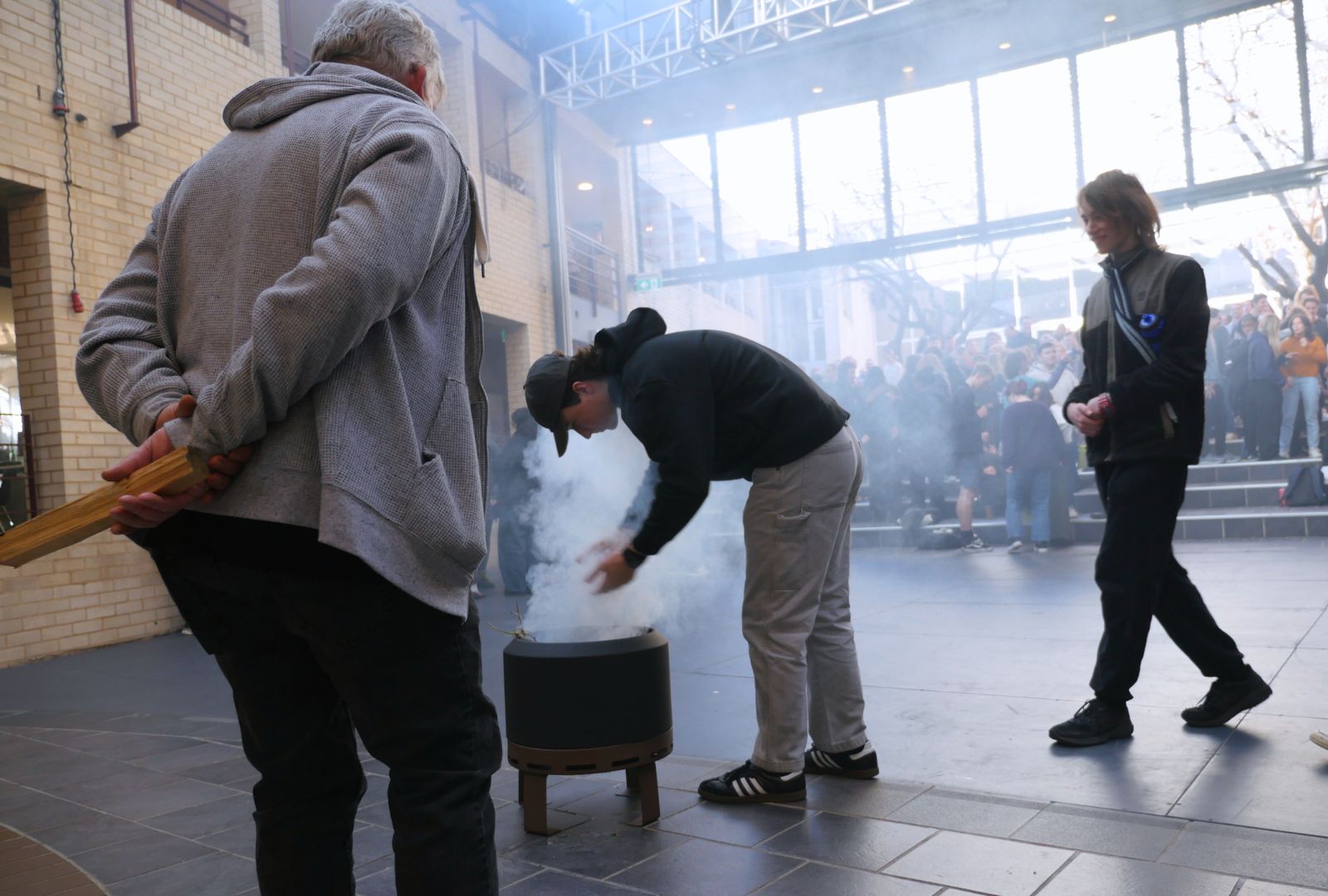 Uncle Matt performing a smoking ceremony with students cleansing themselves.