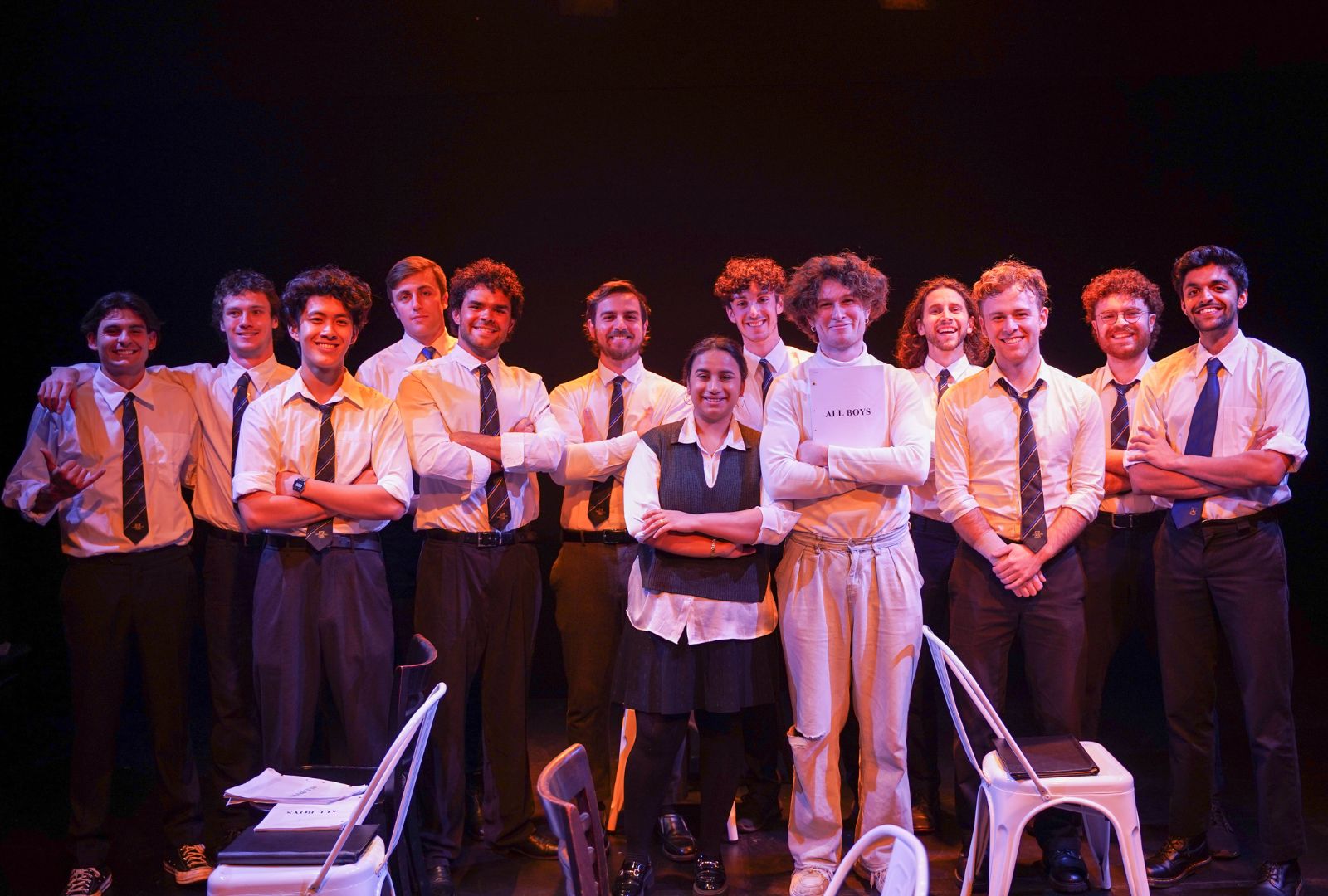 The original cast of ALL BOYS standing in a line on stage smiling.