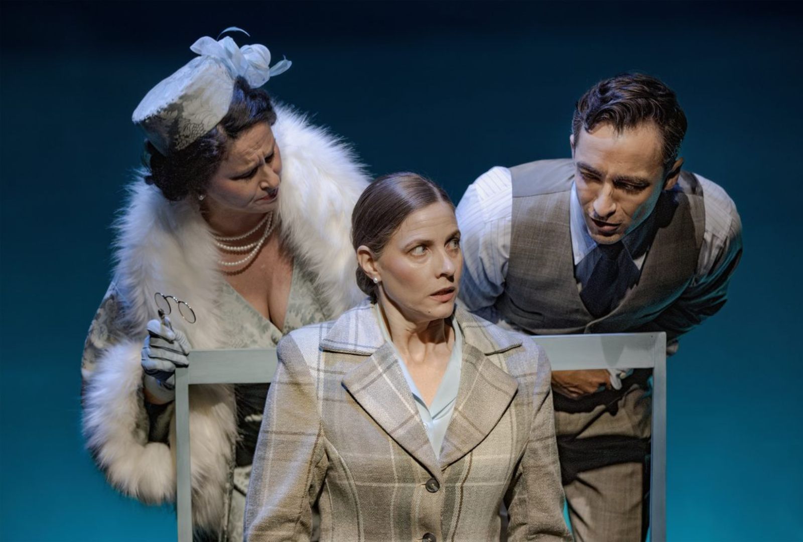 Emma Palmer and Matthew Backer leaning over Elizabeth Blackmore in 'The Queen's Nanny'. They are dressed in