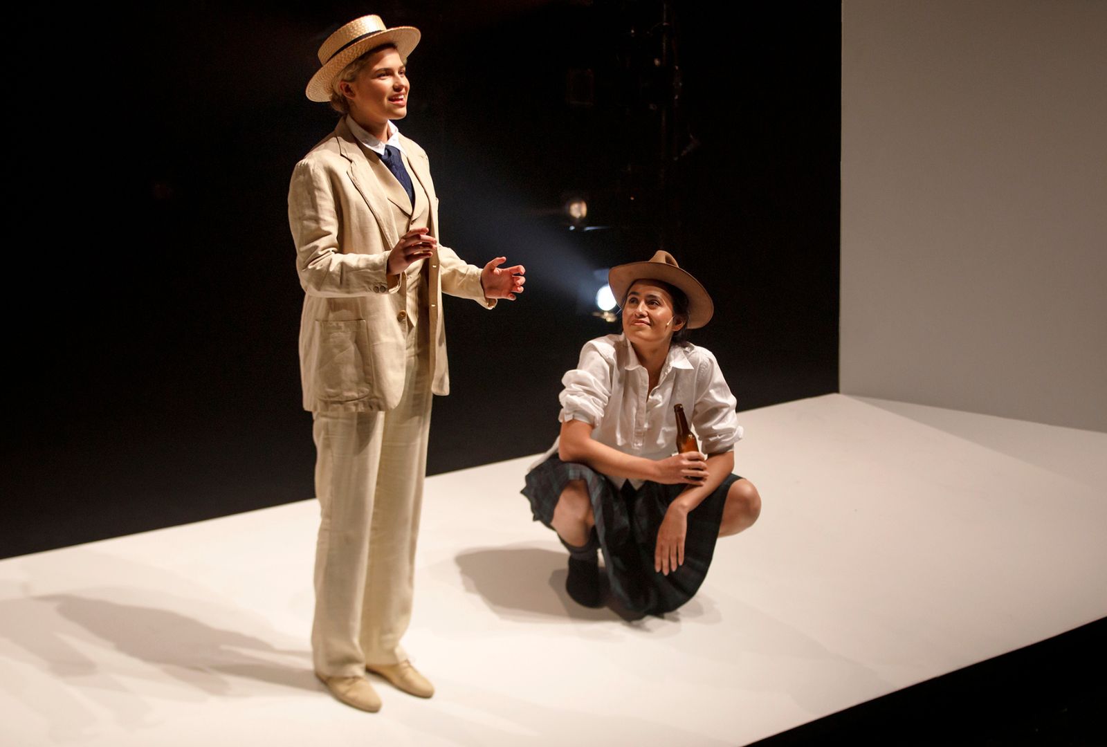 Clare Hughes wearing a linen suit and straw hat and Jessica Bentley crouched down with a beer bottle.